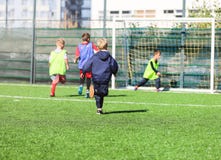Voetbalteam - jongens in rood en blauw, groen eenvormig spelvoetbal op het groene gebied Teamspel, opleiding, actieve levensstijl royalty-vrije stock afbeelding Voetbalteam - jongens in rood en blauw, groen eenvormig spelvoetbal op het groene gebied Teamspel, opleiding, actieve levensstijl royalty-vrije stock afbeelding
