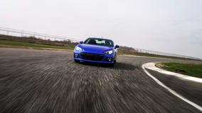 Voiture de sport bleue sur le chemin de course photographie stock libre de droits Voiture de sport bleue sur le chemin de course photographie stock libre de droits