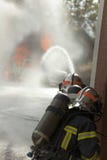 Voiture sur la flamme de brûlure du feu et la brigade de deux sapeurs-pompiers avec le casque images libres de droits Voiture sur la flamme de brûlure du feu et la brigade de deux sapeurs-pompiers avec le casque images libres de droits
