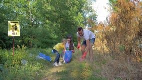 Volontaires de famille, jeune mère et père avec soin de fille d'enfant au sujet de nature d'écologie et rassembler les déchets en banque de vidéos Volontaires de famille, jeune mère et père avec soin de fille d'enfant au sujet de nature d'écologie et rassembler les déchets en banque de vidéos