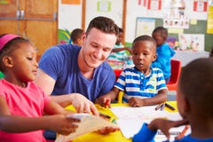 Volunteer teacher sitting with preschool kids in a classroom stock photography Volunteer teacher sitting with preschool kids in a classroom stock photography