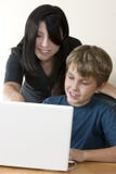 Volwassen vrouw en kind bij computer royalty-vrije stock foto Volwassen vrouw en kind bij computer royalty-vrije stock foto