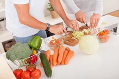 Von mittlerem Alter Paare, die eine Mahlzeit vorbereiten stockbild Von mittlerem Alter Paare, die eine Mahlzeit vorbereiten stockbild