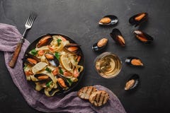 Vongole dos espaguetes, massa italiana do marisco com moluscos e mexilhões, na placa com ervas e vidro do vinho branco na pedra r fotos de stock royalty free Vongole dos espaguetes, massa italiana do marisco com moluscos e mexilhões, na placa com ervas e vidro do vinho branco na pedra r fotos de stock royalty free