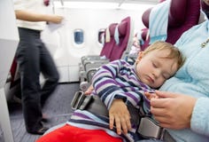 Sira de mãe e curso do bebé da criança de dois anos do sono no avião foto de stock Sira de mãe e curso do bebé da criança de dois anos do sono no avião foto de stock