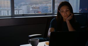 Vooraanzicht van het jonge Kaukasische vrouwelijke uitvoerende werken aan laptop bij lijst in modern bureau 4k stock footage Vooraanzicht van het jonge Kaukasische vrouwelijke uitvoerende werken aan laptop bij lijst in modern bureau 4k stock footage