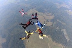 Vorming het skydiving Een groep skydivers doet opeenvolgend in de hemel royalty-vrije stock afbeeldingen Vorming het skydiving Een groep skydivers doet opeenvolgend in de hemel royalty-vrije stock afbeeldingen