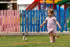 Voronezh, Russie : Le 17 juin 2013 Une fille avec un chien fonctionnant sous l'eau en parc un jour ensoleillé chaud photos libres de droits Voronezh, Russie : Le 17 juin 2013 Une fille avec un chien fonctionnant sous l'eau en parc un jour ensoleillé chaud photos libres de droits