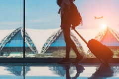 Voyage de femme de silhouette avec la fenêtre latérale de marche de bagage à l'international de terminal d'aéroport images stock Voyage de femme de silhouette avec la fenêtre latérale de marche de bagage à l'international de terminal d'aéroport images stock