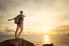 Voyageur heureux insouciant de femme avec le sac à dos appréciant la vue de coucher du soleil photographie stock Voyageur heureux insouciant de femme avec le sac à dos appréciant la vue de coucher du soleil photographie stock