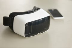 VR hoofdtelefoon en smartphone op bureau, virtuele werkelijkheids mobiele techno royalty-vrije stock fotografie VR hoofdtelefoon en smartphone op bureau, virtuele werkelijkheids mobiele techno royalty-vrije stock fotografie