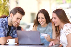 Vrienden die online met een creditcard en laptop winkelen stock afbeeldingen Vrienden die online met een creditcard en laptop winkelen stock afbeeldingen