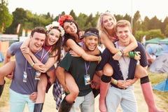 Vrienden die vervoer per kangoeroewagen geven door het kampeerterrein van het muziekfestival royalty-vrije stock foto Vrienden die vervoer per kangoeroewagen geven door het kampeerterrein van het muziekfestival royalty-vrije stock foto