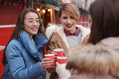 Vrienden met koppen van overwogen wijn bij de wintermarkt stock afbeeldingen Vrienden met koppen van overwogen wijn bij de wintermarkt stock afbeeldingen