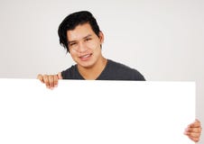 Vriendschappelijke jonge latino mens die wit teken houden Royalty-vrije Stock Fotografie Vriendschappelijke jonge latino mens die wit teken houden Royalty-vrije Stock Fotografie