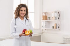 Vriendschappelijke voedingsdeskundige die vers fruit, exemplaarruimte houden stock foto's Vriendschappelijke voedingsdeskundige die vers fruit, exemplaarruimte houden stock foto's
