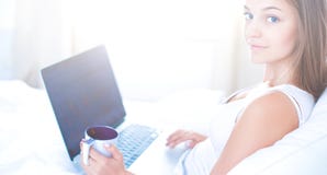 Vrij jonge vrouw met laptop in bed en het genieten van een van kop thee Royalty-vrije Stock Foto Vrij jonge vrouw met laptop in bed en het genieten van een van kop thee Royalty-vrije Stock Foto