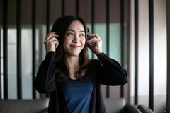 Vrij mooie Aziatische vrouw die hoofdtelefoon en het luisteren muziek dragen stock afbeelding Vrij mooie Aziatische vrouw die hoofdtelefoon en het luisteren muziek dragen stock afbeelding
