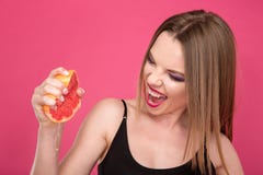 Vrij opgetogen vrouw die grapefruit juice drukken door handen royalty-vrije stock foto Vrij opgetogen vrouw die grapefruit juice drukken door handen royalty-vrije stock foto