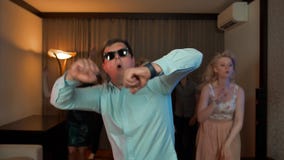 Vrolijk nerdmannetje met en glazen die dansen partying stock footage Vrolijk nerdmannetje met en glazen die dansen partying stock footage