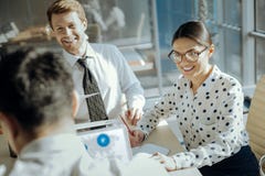 Vrolijke beambten die terwijl het luisteren aan hun collega het spreken glimlachen stock fotografie Vrolijke beambten die terwijl het luisteren aan hun collega het spreken glimlachen stock fotografie