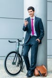 Vrolijke jonge mens die op mobiele telefoon communiceren terwijl het wachten van o royalty-vrije stock afbeelding Vrolijke jonge mens die op mobiele telefoon communiceren terwijl het wachten van o royalty-vrije stock afbeelding