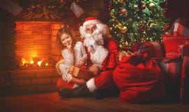 Vrolijke Kerstmis! het meisje van de Kerstman en van het kind bij nacht in Chr Stock Foto's Vrolijke Kerstmis! het meisje van de Kerstman en van het kind bij nacht in Chr Stock Foto's