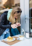 Vrouw die beeld van haar ontbijt van de koffiewinkel nemen stock afbeeldingen Vrouw die beeld van haar ontbijt van de koffiewinkel nemen stock afbeeldingen
