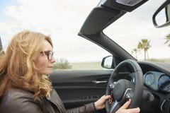 Vrouw die haar cabriolet sportwagen drijven stock afbeeldingen Vrouw die haar cabriolet sportwagen drijven stock afbeeldingen