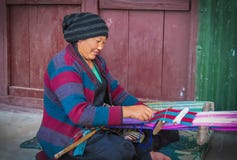Vrouw die manueel een stuk van doekzitting buiten weven ter plaatse in een klein bergdorp in oosten-Nepal royalty-vrije stock foto Vrouw die manueel een stuk van doekzitting buiten weven ter plaatse in een klein bergdorp in oosten-Nepal royalty-vrije stock foto