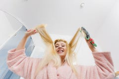 Vrouw die peignoir dragen die haar haar borstelen Royalty-vrije Stock Afbeeldingen Vrouw die peignoir dragen die haar haar borstelen Royalty-vrije Stock Afbeeldingen