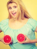Vrouw die rode grapefruit op borst houden Stock Afbeeldingen Vrouw die rode grapefruit op borst houden Stock Afbeeldingen