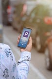 Vrouw die smartphone app gebruiken om voor parkeren te betalen stock afbeeldingen Vrouw die smartphone app gebruiken om voor parkeren te betalen stock afbeeldingen