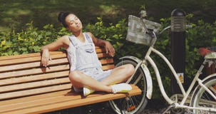 Vrouw die van zon op bank in park genieten stock afbeelding Vrouw die van zon op bank in park genieten stock afbeelding