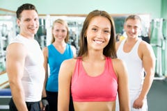Vrouw die voor een groep gymnastiekmensen glimlachen stock afbeelding Vrouw die voor een groep gymnastiekmensen glimlachen stock afbeelding