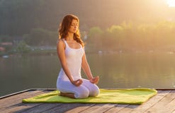 Vrouw die yoga op de kust doen - halve cijferzitting royalty-vrije stock afbeeldingen Vrouw die yoga op de kust doen - halve cijferzitting royalty-vrije stock afbeeldingen