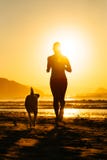 Vrouw en hond die naar de zon lopen stock fotografie Vrouw en hond die naar de zon lopen stock fotografie