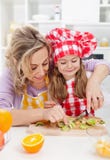Vrouw en meisje die verse vruchten snack maken stock afbeeldingen Vrouw en meisje die verse vruchten snack maken stock afbeeldingen