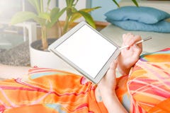 Vrouw in kleurrijke kleding in een woonkamer die met een pen op de witte tablet schrijven stock foto's Vrouw in kleurrijke kleding in een woonkamer die met een pen op de witte tablet schrijven stock foto's