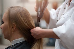 Vrouw in salon en kapper met een hairdryer stock fotografie Vrouw in salon en kapper met een hairdryer stock fotografie