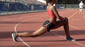 Vrouwelijke atleet die gymnastiek doen bij stadion, die spieren voor de concurrentie opwarmen royalty-vrije stock foto's Vrouwelijke atleet die gymnastiek doen bij stadion, die spieren voor de concurrentie opwarmen royalty-vrije stock foto's