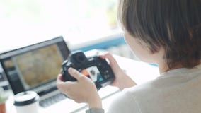 Vrouwelijke fotograaf het herzien foto's op haar camera thuis stock footage Vrouwelijke fotograaf het herzien foto's op haar camera thuis stock footage