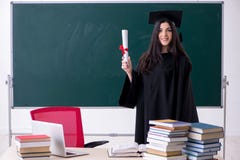 Vrouwelijke gediplomeerde student voor groene raad stock foto Vrouwelijke gediplomeerde student voor groene raad stock foto