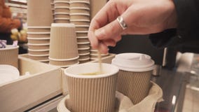 Vrouwelijke hand het bewegen suiker in een kop van koffie stock footage Vrouwelijke hand het bewegen suiker in een kop van koffie stock footage