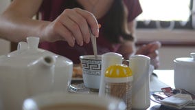 Vrouwelijke Hand het Bewegen Suiker of Melk in een kop van Hete Koffie of Thee Sluit omhoog stock footage Vrouwelijke Hand het Bewegen Suiker of Melk in een kop van Hete Koffie of Thee Sluit omhoog stock footage