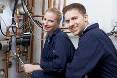 Vrouwelijke het Verwarmen van Working On Central van de Stagiairloodgieter Boiler royalty-vrije stock fotografie Vrouwelijke het Verwarmen van Working On Central van de Stagiairloodgieter Boiler royalty-vrije stock fotografie