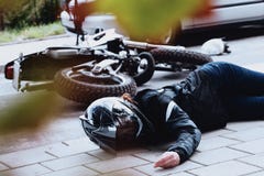 Vrouwelijke motorrijder die onbewust liggen royalty-vrije stock fotografie Vrouwelijke motorrijder die onbewust liggen royalty-vrije stock fotografie