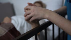 Vrouwelijke patiënt die in slaap met TV, gevende verpleegster die haar omvatten met deken vallen stock footage Vrouwelijke patiënt die in slaap met TV, gevende verpleegster die haar omvatten met deken vallen stock footage