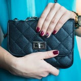Vrouwelijke spijkers met rood nagellak en een mooie zwarte handtas royalty-vrije stock foto's Vrouwelijke spijkers met rood nagellak en een mooie zwarte handtas royalty-vrije stock foto's