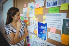 Vrouwelijke stafmedewerker die prikbord bekijken stock afbeeldingen Vrouwelijke stafmedewerker die prikbord bekijken stock afbeeldingen